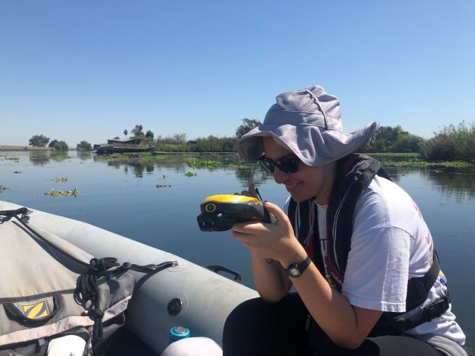 Researcher on boat in Delta waterway