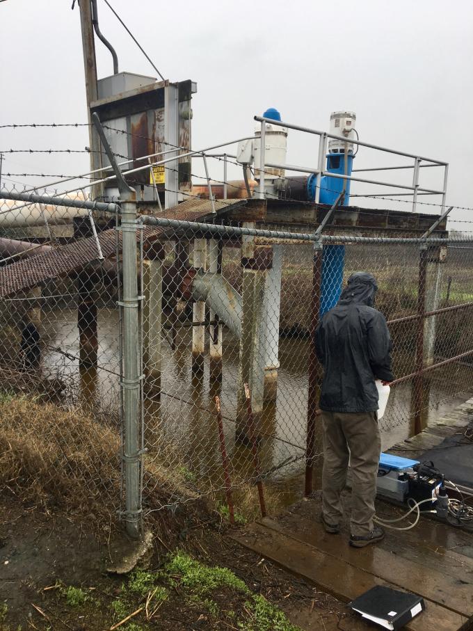 Joseph samples treated wastewater at White Slough Wastewater Pollution Control Facility