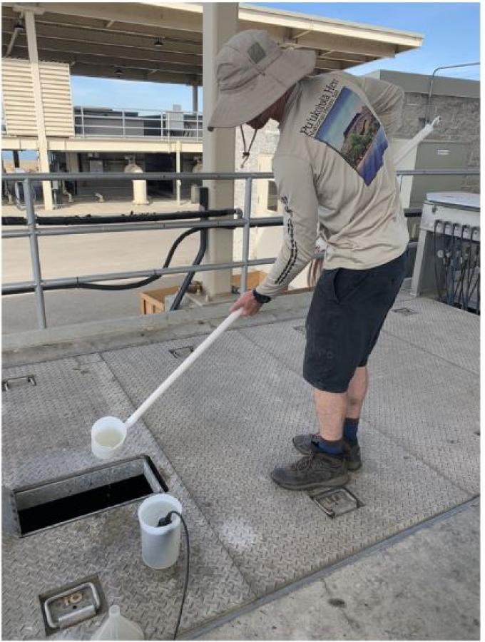 Joseph collects a sample from a pump station on Sherman Island on a rainy winter day. Christina Richardson